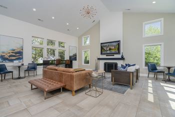 A living room with a brown couch and a fireplace.
